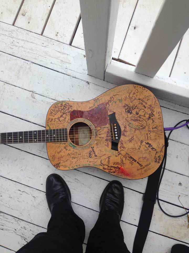 Shoes and guitar on a white porch